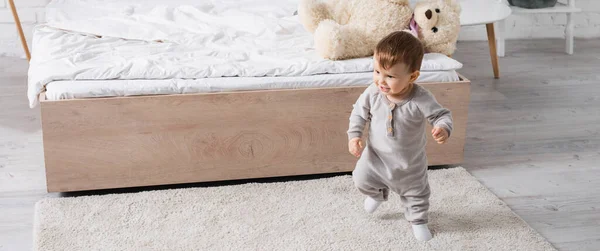 Feliz Bebé Niño Gris Mameluco Caminando Alfombra Cerca Juguete Suave — Foto de Stock