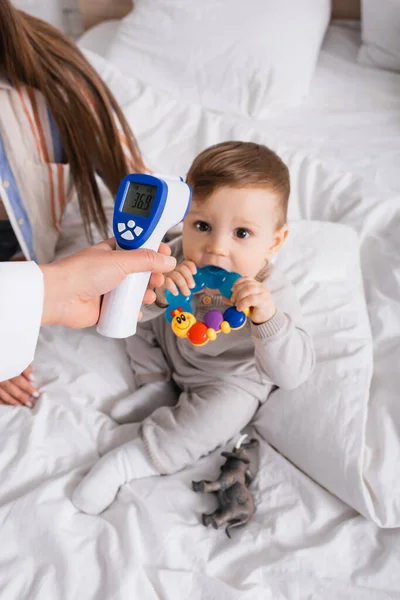 Pediatra Examinando Niño Con Termómetro Sin Contacto Cerca Madre — Foto de Stock