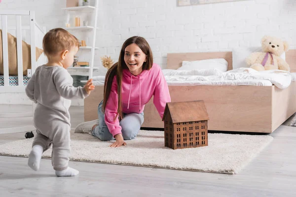 Mère Étonnée Regardant Bébé Garçon Faire Les Premiers Pas — Photo