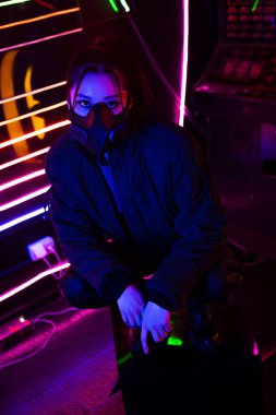 neon lighting on young asian woman in gas mask 