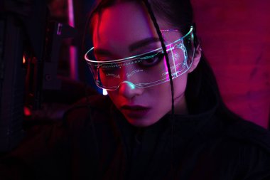 brunette asian woman with artificial scar holding gun and looking at camera