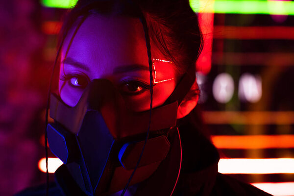 young asian woman in black gas mask looking at camera