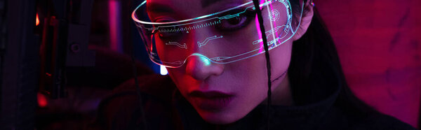 брюнетка азиатская женщина с искусственным шрамом держа пистолет и глядя на камеру, баннер