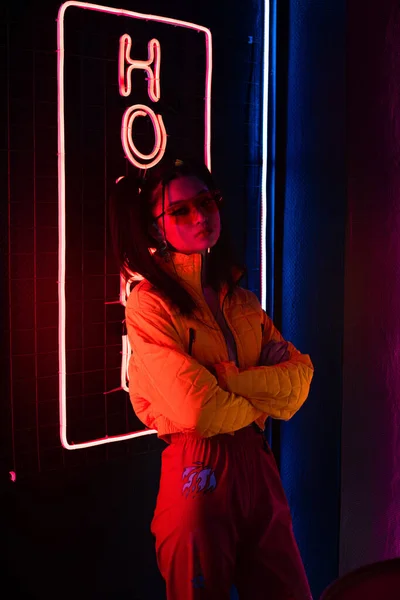 Young Asian Woman Sunglasses Standing Crossed Arms Red Neon Hotel — Foto de Stock