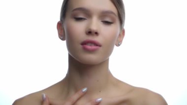 Genç bir kadın köprücük kemiğine dokunuyor. 