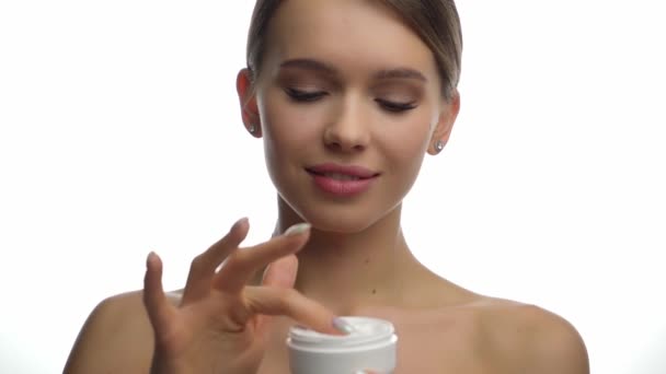 Rallentatore Donna Sorridente Applicare Crema Viso Sul Bianco — Video Stock