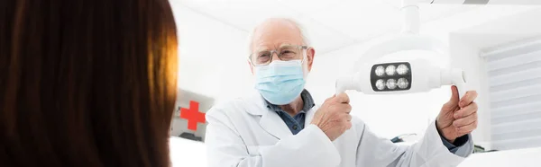 Zahnarzt Medizinischer Maske Berührt Medizinische Lampe Vor Patient Banner — Stockfoto