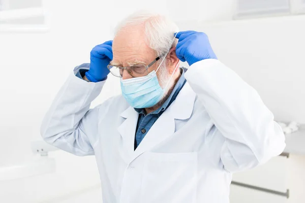 Diş Kliniğinde Tıbbi Maske Takan Lateks Eldivenli Kıdemli Doktor — Stok fotoğraf