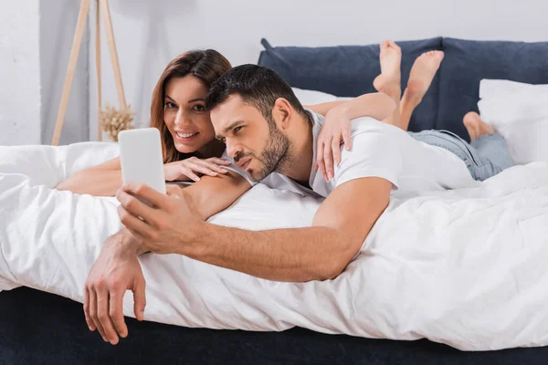 Sorrindo Mulher Abraçando Namorado Durante Selfie Quarto — Fotografia de Stock