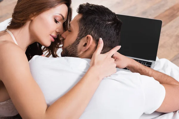 Sexy Woman Kissing Boyfriend Blurred Laptop Bed — Stock Photo, Image