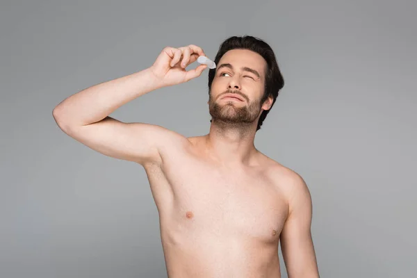 Shirtloze Man Met Gesloten Oog Aanbrengen Oogdruppels Geïsoleerd Grijs — Stockfoto