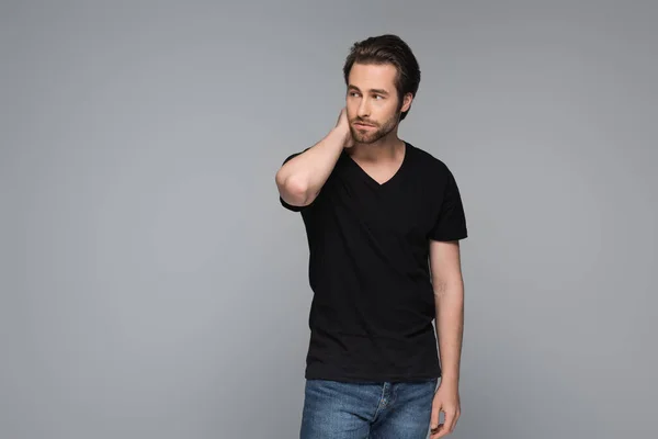 Skäggig Man Svart Shirt Och Jeans Poserar Och Tittar Bort — Stockfoto