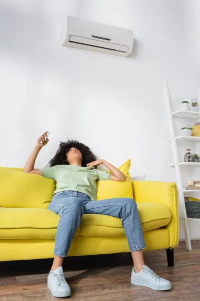 Mulher Afro Americana Descontente Segurando Controlador Remoto Enquanto Sentado Sofá — Fotografia de Stock