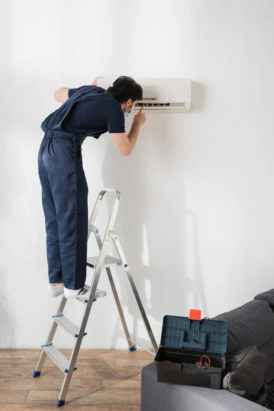 Repairman Medical Mask Standing Metallic Ladder Fixing Air Conditioner — Stock Photo, Image