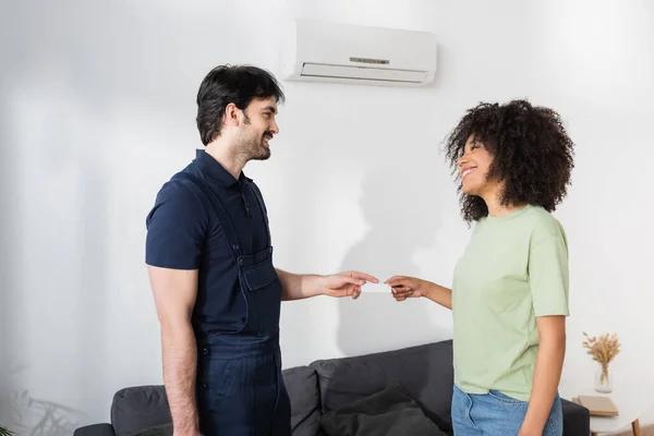 Cheerful Handyman Giving Blank Card Smiling African American Woman — Stock Photo, Image