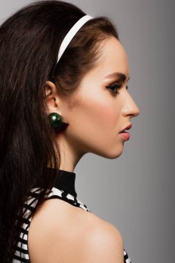 Gri üzerine izole edilmiş güzel genç modelin yan görüntüsü 
