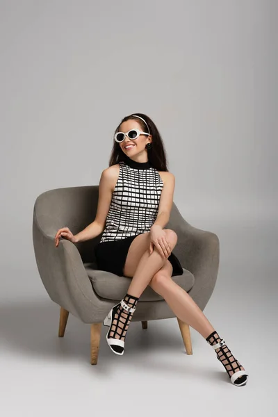 Cheerful Woman Retro Outfit Sunglasses Sitting Armchair Grey — Stock Photo, Image