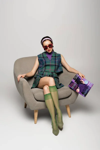 Woman Sunglasses Holding Magazine While Sitting Armchair Grey — Stock Photo, Image