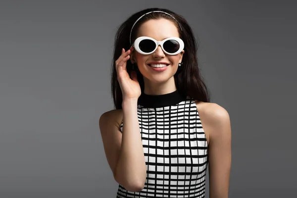 Cheerful Young Woman Adjusting Sunglasses Isolated Grey — Stock Photo, Image