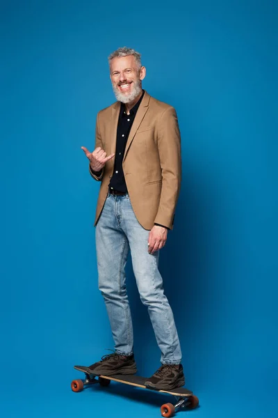 Full Length Pleased Middle Aged Man Riding Longboard Showing Call — Stock Photo, Image