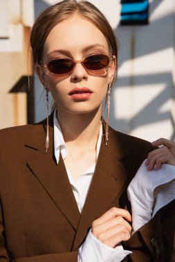 Güneş gözlüklü, çatıda poz veren güzel genç bir model. 