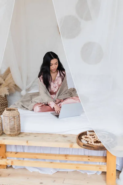 Serious Young Asian Woman Silk Pajamas Blanket Sitting Bed Crossed — Stock Photo, Image