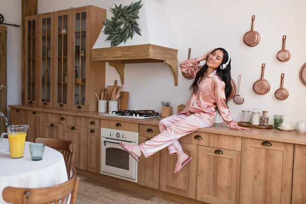 Young Asian Woman Pink Silk Pajamas Headphones Sitting Stove Enjoying — Stock Photo, Image