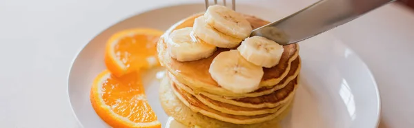 Närbild Kniv Skärande Pannkakor Med Orange Och Banan Skivor Vit — Stockfoto