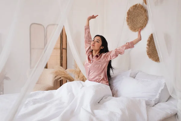 Pek Pijamalı Genç Asyalı Kadın Yatak Odasında Uzanmış Ellerle Uyanıyor — Stok fotoğraf