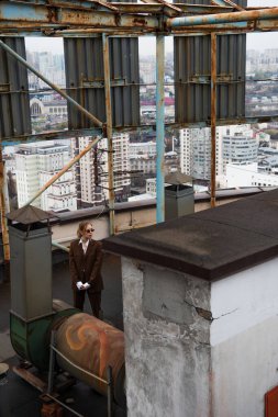 Güneş gözlüklü şık bir kadının çatıda dikilirken yüksek açılı görüntüsü 