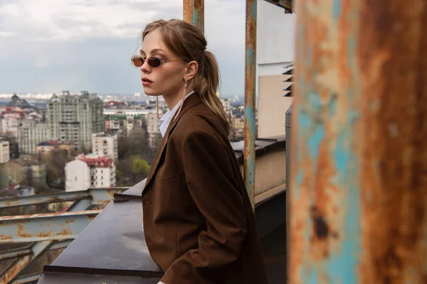 Mujer Reflexiva Gafas Sol Elegantes Posando Azotea Con Paisaje Urbano — Foto de Stock