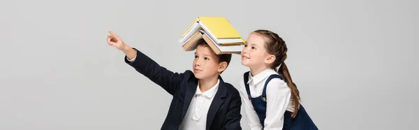 Scolaro Con Libri Sulla Testa Che Puntano Con Dito Vicino — Foto Stock