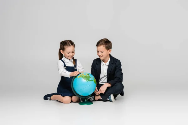 Colegiala Feliz Colegial Mirando Globo Mientras Está Sentado Gris — Foto de Stock