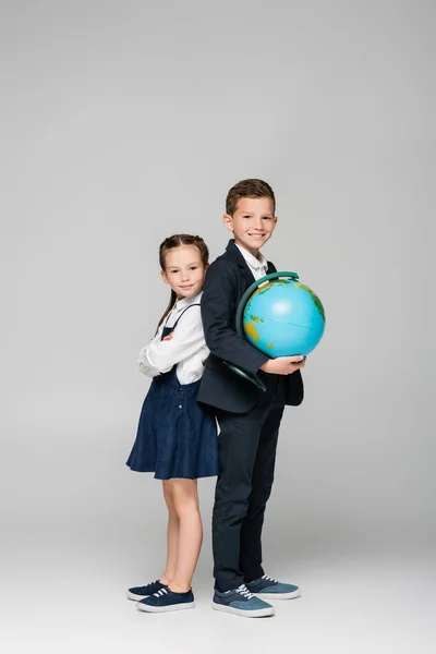 Estudante Feliz Segurando Globo Enquanto Está Com Menina Vestido Cinza — Fotografia de Stock