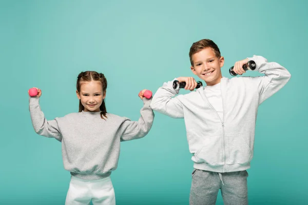 Crianças Esportivas Sportswear Trabalhando Com Halteres Sorrindo Isolado Azul — Fotografia de Stock