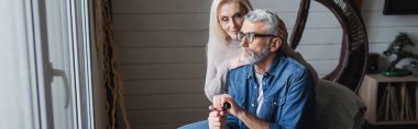 Woman hugging senior husband with crutch, banner 