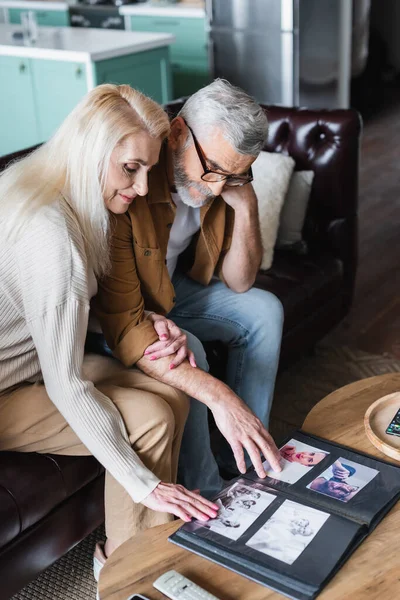 Elderly Family Looking Photos Album Coffee Table — Stockfoto
