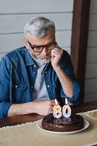 Homem Solitário Olhando Para Bolo Aniversário Borrado Com Velas Forma — Fotografia de Stock