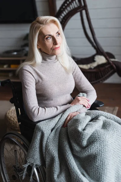家で椅子に座っている間に毛布を持っている高齢女性 — ストック写真