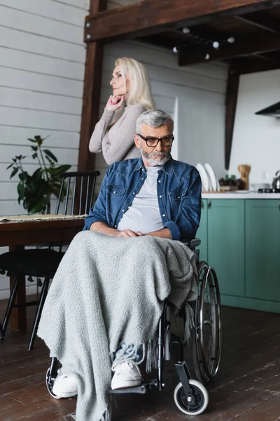 Грустный Инвалид Инвалидной Коляске Смотрит Вдали Жены Дома — стоковое фото