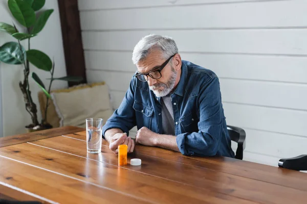 Lonely Senior Man Holding Pill Water Table — Stockfoto