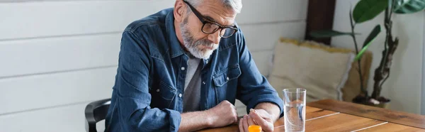 Älterer Mann Hält Tablette Der Nähe Von Glas Wasser Auf — Stockfoto