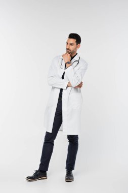 Tam boy Müslüman doktor gri arka plana bakıyor.