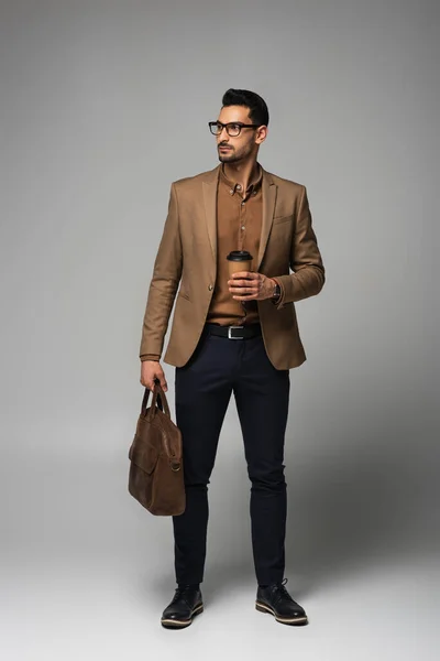 Muslim Businessman Brown Jacket Holding Paper Cup Handbag Grey Background — Stock Photo, Image