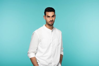 Deli Arap adam mavi kameraya bakıyor. 