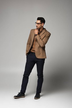 Sakallı Arap işadamı gri arka plana bakıyor 