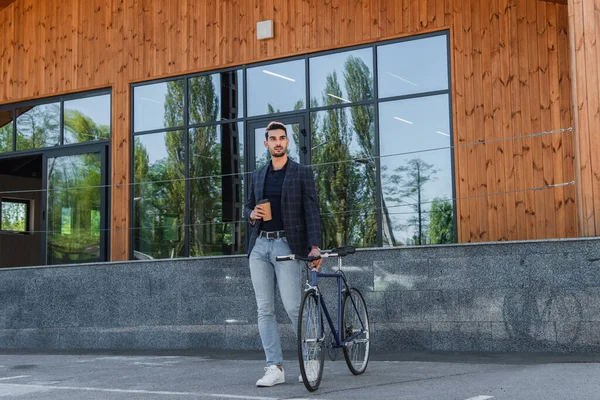 Jovem Gerente Árabe Segurando Copo Papel Perto Bicicleta Construção — Fotografia de Stock