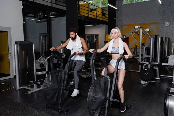 Blond Kvinna Och Skäggig Afrikansk Amerikansk Man Utbildning Träningsmaskiner Gym — Stockfoto