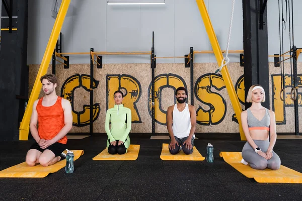 Interrazziale Persone Meditando Thunderbolt Posa Centro Sportivo — Foto Stock