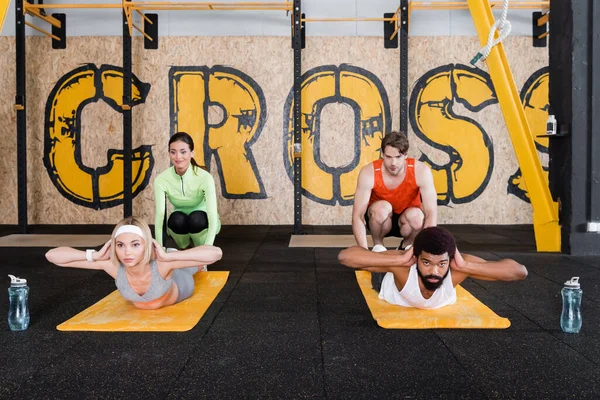 Young Trainers Assisting Interracial Sports People Doing Abs Exercise Gym — Stock Photo, Image